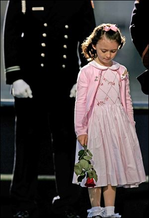 The daughter of a police office killed on 9-11 stands on stage during the reading of victims' names during ceremonies Sept. 11, 2006, at Ground Zero in New York. 