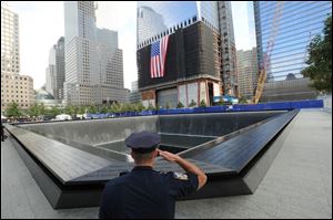 Danny Shea, a New York City Police Officer and military veteran, salutes at the north pool of the Sept 11. Memorial, during 10th anniversary ceremonies at the World Trade Center site.