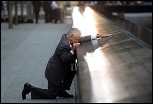 Robert Peraza, who lost his son Robert David Peraza in the attacks at the World Trade Center, pauses at his son's name at the North Pool of the 9/11 Memorial in New York.