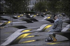 Maj. Tevye Yoblick spends a quiet moment at dawn at the Pentagon Memorial. The memorial includes an illuminated bench for each victim of the attack on the U.S. Defense Department's headquarters.