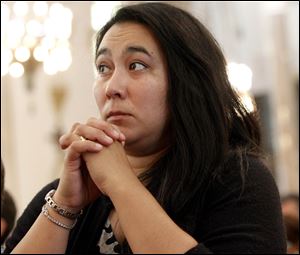 Sarah Mercurio, wife of Toledo Firefighter Jason Mercurio from Station 16, prays during the Mass.
