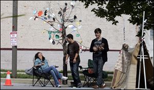 Kate Abu-Absi, director of the UT Arts Living and Learning Community, relaxes under a 'tree' on her park on Adam's Street during Park(ing) Day. She's with Justin Maxwell and ukulele player Matt Muha, both students at the University of Toledo.  UT occupied five of the 29 spaces.