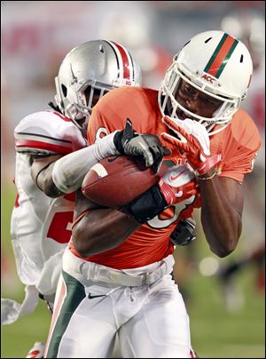 Miami wide receiver Tommy Streeter pulls in a pass in front of Ohio State defensive back Bradley Roby during the second quarter of Saturday night’s game. The No. 17 Buckeyes fell to 2-1.