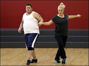 Chaz Bono, left, and Lacey Schwimmer practice dance steps while rehearsing for the upcoming season of 