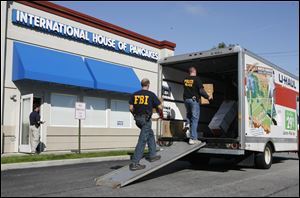 Law enforcement officials remove boxes from the IHOP restaurant on Airport Highway in Holland on Tuesday morning.