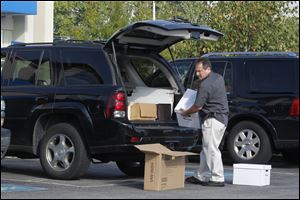 An unidentified man loads the trunk of an SUV with boxes taken from an IHOP on Talmadge Road.