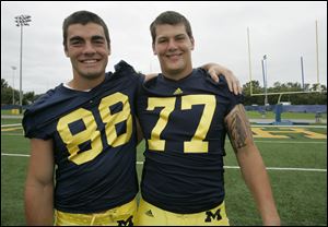 University of Michigan football players Craig Roh, left, and Taylor Lewan, right, pose together on media day in Ann Arbor, Michigan.