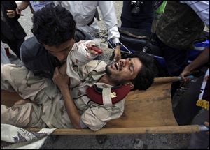 Anti-government fighters carry a wounded defector soldier from the site of clashes with security forces in Sanaa, Yemen. About 1,000 people, mostly unarmed demonstrators, were reported injured in 2 days of violence.