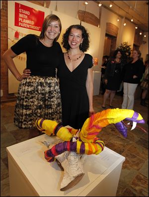 Molly Datson, left, and Maara Fink stand behind a snake made of condoms.