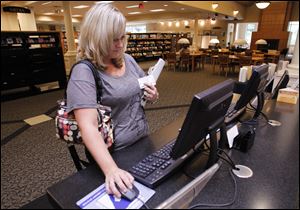 Barb Rahman of Temperance uses a computer at the library, where, officials say, the current 13 are often all in use. The branch also is to acquire a third printer.