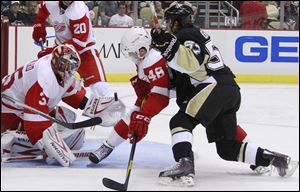 Detroit Red Wings goalie Jimmy Howard, left, gloves a rebound on a shot by Pittsburgh Penguins' Brian Gibbons, right, with help from Cory Emmerton (48) during the second period Wednesday night.