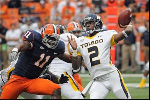 Toledo quarterback Terrance Owens (2) throws a pass as Syracuse's  Marquis Spruil, left, rushes in during the first half of an NCAA college football game Saturday in Syracuse, N.Y. 