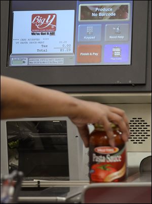 A customer uses a self-serve checkout station at a Big Y supermarket in Manchester, Conn. A growing number of supermarket chains are bagging their self-serve checkout lanes, saying they can offer better customer service when clerks help shoppers directly. 