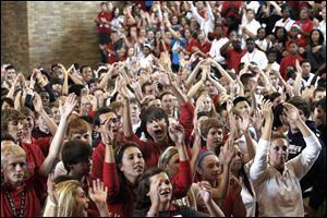 Central Catholic High School student Derrick Johnson, center with arm raised, and eighth graders from Joan of Arc, Regina Coeli, and St. John the Baptist schools leave Central Catholic High School enjoy a pep rally during  