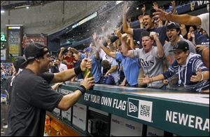 Tampa Bay Rays' Evan Longoria, left, sprays fans early Thursday after the Rays clinched the AL wild card with an 8-7 win over the New York Yankees.
