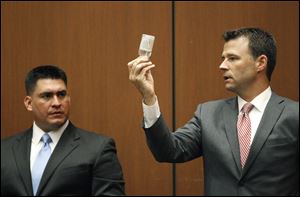 Deputy District. Attorney. David Walgren, holding a bottle of propofol, questions Alberto Alvarez, one of Michael Jackson's security guards, during Conrad Murray's involuntary manslaughter trial in downtown Los Angeles, Thursday.  Murray has pleaded not guilty and faces four years in prison and the loss of his medical license if convicted of involuntary manslaughter in Michael Jackson's death.