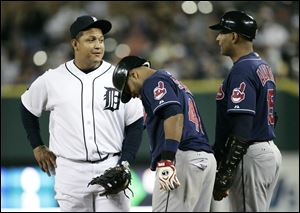 Detroit Tigers' Miguel Cabrera, left, talks with Cleveland Indians' Carlos Santana and first base coach Sandy Alomar in the fourth inning of a baseball game on Wednesday, Sept. 28, 2011, in Detroit. Cabrera singled and doubled in the Tigers' 5-4 win.