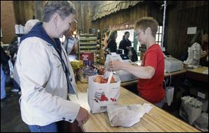 Barbara DeGrande, left, of Farmington Hills, Mich.,  buys apples from  Valerie Mitchell at Erie Orchards and Cider Mill in Erie, Mich.