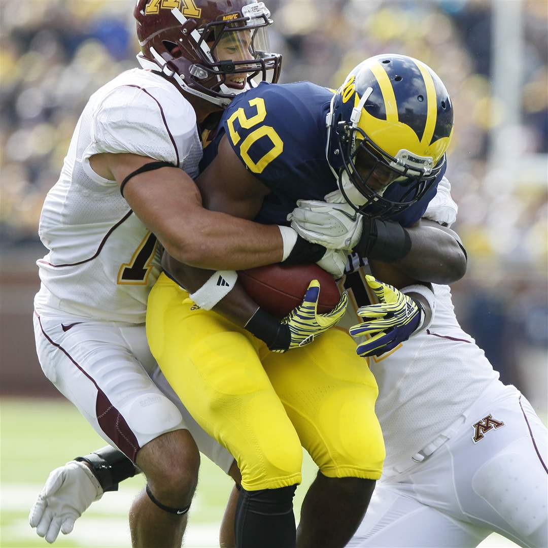 Michigan-s-Michael-Shaw-is-tackled-by-the-Gophers-defense