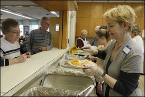 Janette and Merlin Wahl, left, of Blissfield are served a pork roast dinner from volunteers at Zion Lutheran Church's German Celebration dinner.