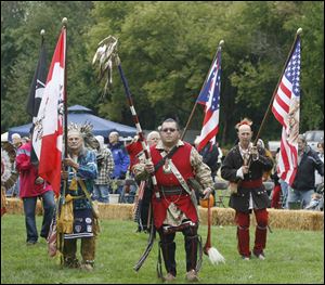 Joe Gutshall of Dunkirk, Ind., left, carries a special flag of Canada and the people of the first nations, left; Brian Darst of Sedalia, Ohio, carries the 9-11 eagle staff; and Don Holsinger of Archbold, carries a special flag of the U.S. and native Americans. 
