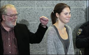 Amanda Knox, right, is cheered by family friend Dave Marriott as she arrives for a news conference shortly after her arrival at Seattle-Tacoma International Airport Tuesday, Oct. 4, 2011, in Seattle.