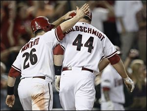 Arizona Diamondbacks' Paul Goldschmidt (44) is congratulated by Miguel Montero following his fifth-inning grand slam in Game 3 of baseball's National League division series against the Milwaukee Brewers on Tuesday, Oct. 4, 2011, in Phoenix.