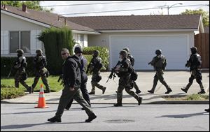 Police search a neighborhood where authorities say the suspect fled in Cupertino, Calif., Wednesday.