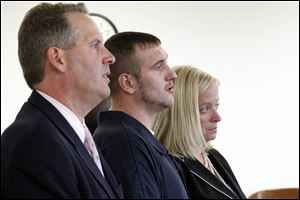 Attorneys John Thebes, left, and Jane Roman, right, flank Samuel Todd Williams, center, during his arraignment in Lucas County Common Pleas Court Wednesday.