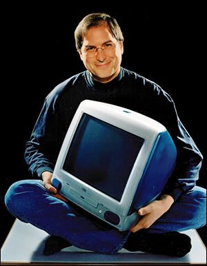 This 1998 file photo provided by Apple shows Apple CEO Steve Jobs holding an iMac computer.