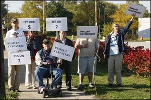 A small group of supporters of State Issue 2, including Todd Smith of Toledo, left, and John Marshall of Sylvania Township, seated, express their support for the issue Wednesday during a We Are Ohio bus tour stop in Toledo.