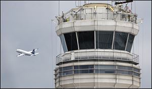 A passenger jet flies past the FAA control tower at Washington's Ronald Reagan National Airport. 