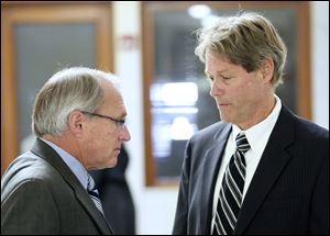 Former Toledo Fire Chief Mike Wolever, left, talks to his son's attorney, George Gerken, after Wednesday's hearing. 