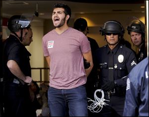 One of several demonstrators is taken into custody by police after refusing to leave a Bank of America branch in downtown Los Angeles, Thursday. The arrests Thursday afternoon came at the end of a demonstration that moved among high-rises housing the offices of banks and other financial institutions.