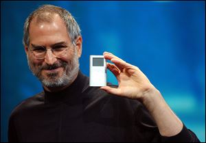 Apple CEO Steve Jobs displays the iPod mini at the Macworld Conference and Expo in San Francisco in this Jan. 6, 2004 file photo.