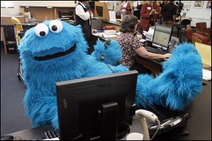 Cookie Monster from the TV show 'Sesame Street' makes himself at home at the Toledo-Lucas County Public Library, where he was on hand for a grant announcement.