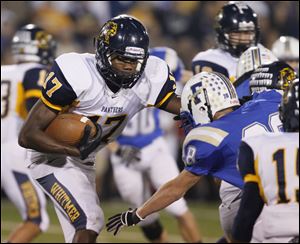Whitmer's Mark Meyers dodges Findlay defender Aaron Doty while running the ball during Friday night's game at Findlay.