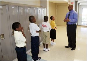 Principal Anthony Bronaugh, right, stops to compliment a group of students who are waiting patiently, quietly and in line for their classmates. Robinson Elementary School, with grades K-8, starts the school year on August 29, 2011. The school is hoping to transform itself with a new principal and with teachers who want to teach there, and who were selected on the basis of their commitment and excellence. The Blade/Jetta Fraser