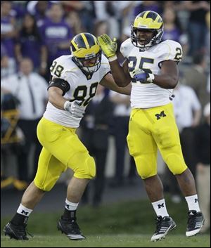 Michigan’s Kenny Demens, right, celebrates with Craig Roh after Demens sacked Northwestern’s Dan Persa.