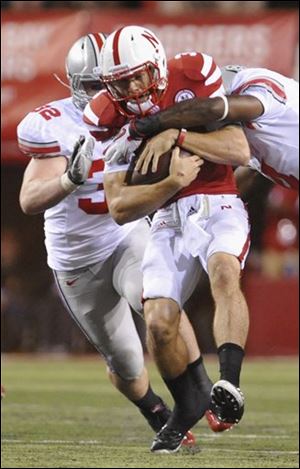 Ohio State’s C.J. Barnett, right, sacks Nebraska quarterback Taylor Martinez as Storm Klein (32) moves in.