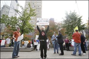 Achilles Freeman of Toledo holds a sign during the 'Occupy Toledo' rally at Levis Square in downtown Toledo Monday.