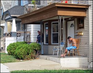 Carlos Mercado, left, grandfather, and the brother of Christian Mercado, right, father of Maritza Ramirez-Cruz' three children, grieve outside the family Monday, Oct. 10, 2011, in Milwaukee. 