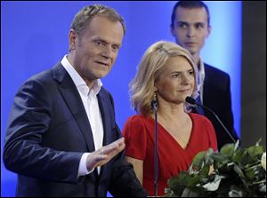 Prime Minister Donald Tusk stands beside his wife Malgorzata, right, as he delivers a speech as the first exit poll have been published during the election party of Tusk's Civic Platform, a centrist and pro-EU party,  in Warsaw.