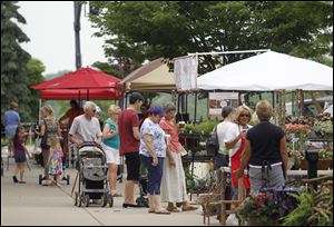 Shoppers look for deals at the Perrysburg Farmers Market in June. Sidewalk permits allow the farmers market to take place.