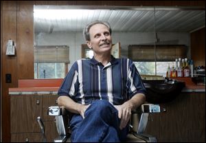 Ron Hurley sits in the chair of his Temperance, Mich., barbershop. He is leaving the trade because of a progressive case of arthritis.