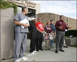 Toledo firefighter and union activist Dan Desmond, at right, is joined by other opponents of Issue 2 at the Chester J. Zablocki Community Center. He says the loss of the minimum manning level of 103 firefighters per shift would be detrimental to seniors because they could be put on hold when calling for assistance. 