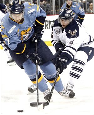 The Walleye's Kyle Rogers, left, battles Greenville's Chris Clackson for the puck. Rogers is the Walleye's second leading returning scorer with 24 assists and 36 points.