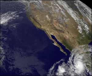 A satellite image of Hurricane Jova, lower right, taken at 12:30 a.m. EDT Wednesday as it approaches the Mexican coastline with maximum sustained winds of 100 mph.