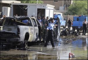 Iraqi security forces stand guard Wednesday in front of a police station at Hurriyah neighborhood in Baghdad, Iraq.