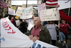 Marsi Digiovanni, of SeaTac, with the Tea Party, joins others demonstrating Sept. 25 outside a fundraising event held by President Barack Obama in downtown Seattle.